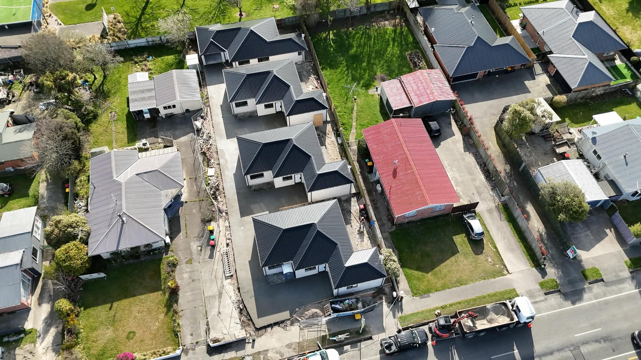 Aerial construction photograph showing the four homes and shared driveway